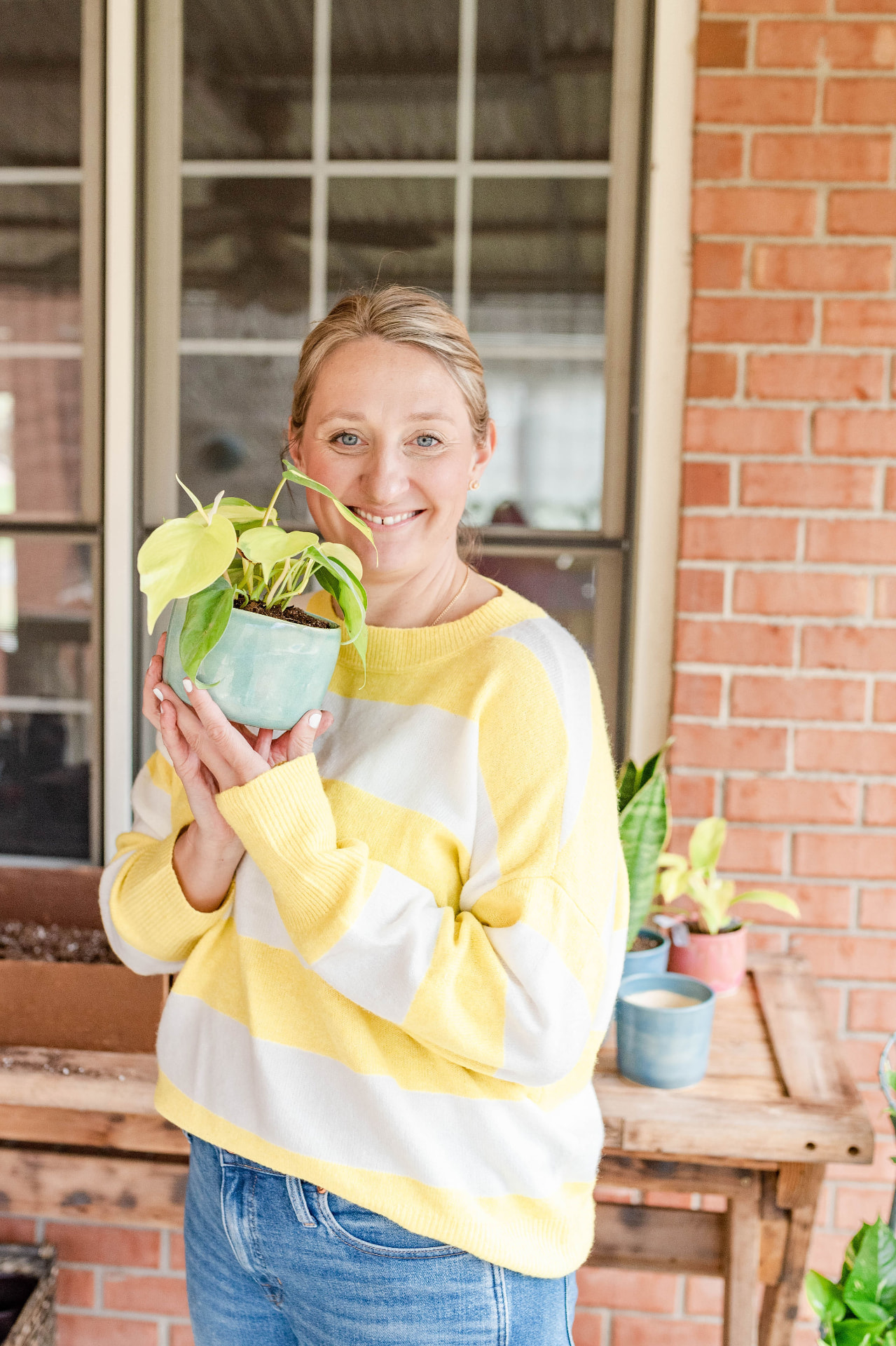 Katie Iarca smiling while holding a small potted plant